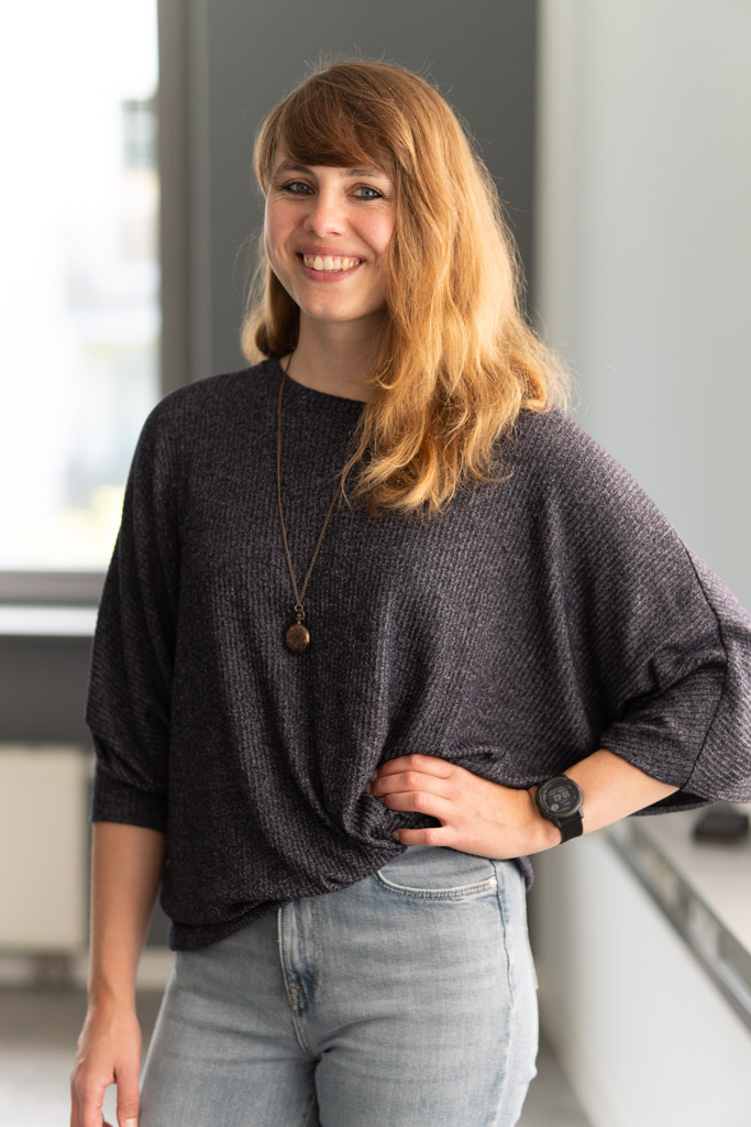 Tahnee Boderius, Sport- und Bewegungstherapeutin mit Bachelor in Gesundheitsmanagement, steht lächelnd in ihrem Praxisraum in Kiel